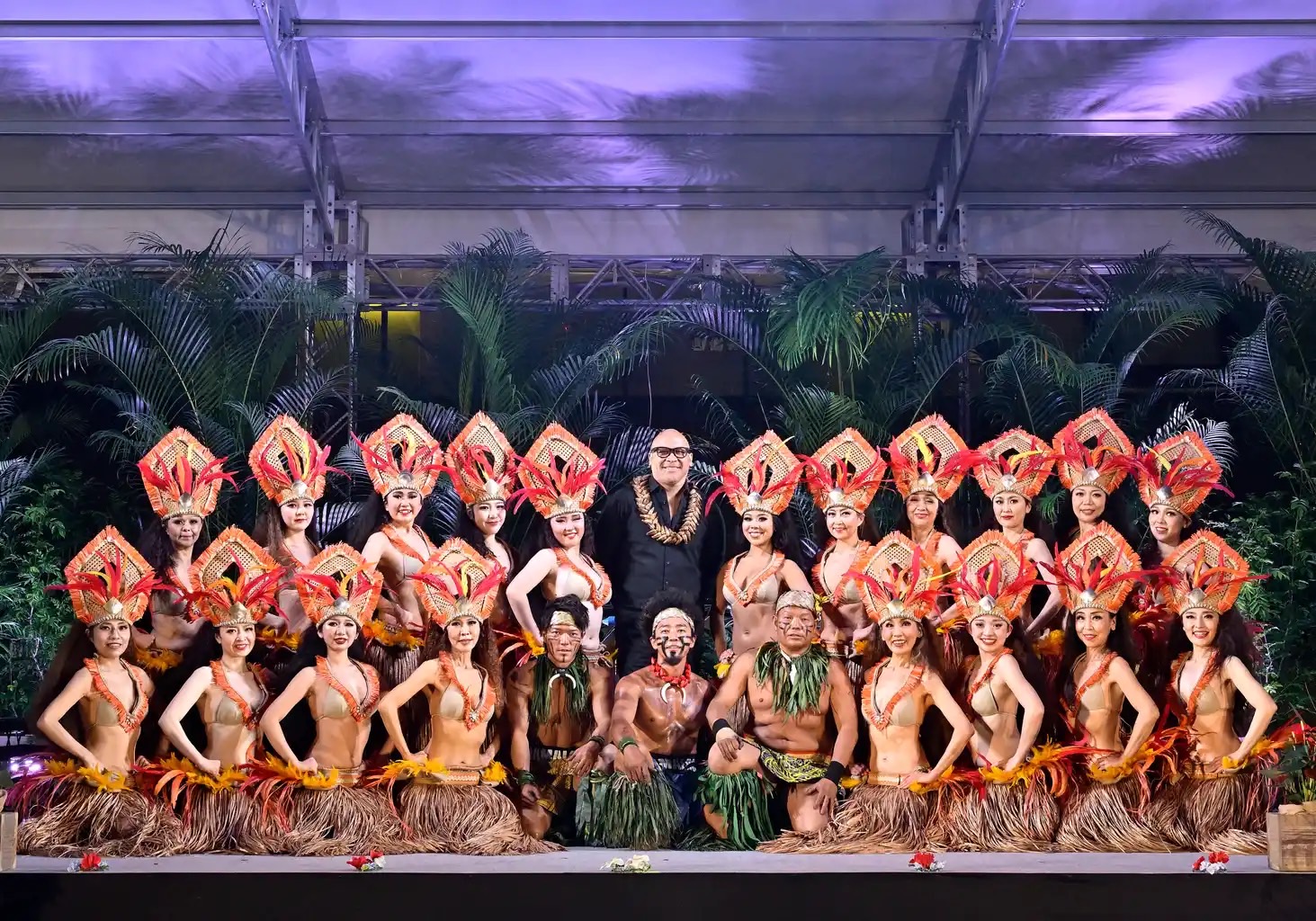 華やかな衣装を着たポリネシアンダンサーとファイヤーナイフダンサーの集合写真